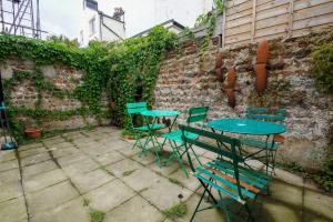 a patio with tables and chairs next to a brick wall at Sudeley House - by Brighton Holiday Lets in Brighton & Hove