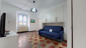 ein Wohnzimmer mit einem blauen Sofa und einem TV in der Unterkunft House Silvia By Holiday World in Genua