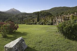 a field with a cemetery with a rock in the grass at Hotel & Resort Sant'Anna Del Volterraio in Portoferraio