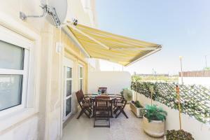 a patio with a table and chairs under a canopy at Best Houses 36 - Baleal Surf Village in Peniche