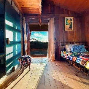 ein Schlafzimmer mit einem Fenster und einem Bett in einem Zimmer in der Unterkunft Pousada Ninho da Gralha in Turvo