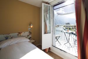 Schlafzimmer mit einem Bett und einem Fenster mit einem Balkon in der Unterkunft Boutique Hotel Bellevue in Interlaken