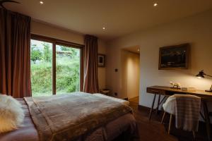 1 dormitorio con cama, escritorio y ventana en Chalet du Rachet Chamonix Mont-Blanc, en Les Houches