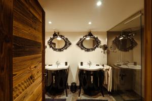 een badkamer met 2 wastafels en spiegels aan de muur bij Chalet du Rachet Chamonix Mont-Blanc in Les Houches