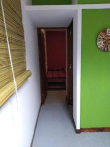 a room with a green wall and a clock at container in San Gerónimo
