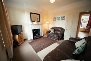 a living room with a couch and a fireplace at Buckenham Cottage in Cromer