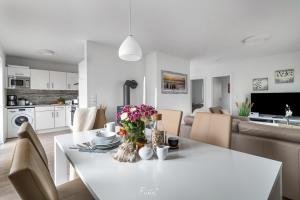 a dining room and kitchen with a white table and chairs at Strandhaus Ambiente 2 in Olpenitz