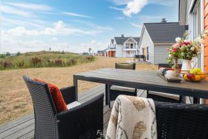 a wooden deck with a table and chairs on the beach at Strandhaus Ambiente 2 in Olpenitz