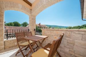 een patio met een tafel en stoelen aan een stenen muur bij Beautiful villa Natura with pool in Labin in Labin
