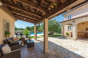an outdoor patio with furniture and a pool at Beautiful villa Natura with pool in Labin in Labin