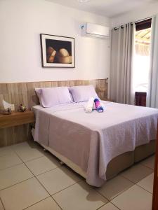 a bedroom with a bed with a stuffed animal on it at Bangalô Eco Residence Flecheiras in Flecheiras +70 photos