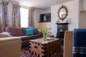 a living room with a couch and a table at Two Sides Cottage in Lymington