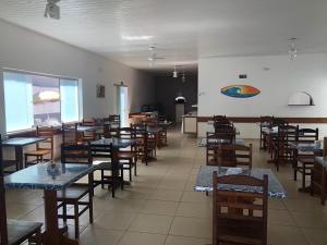 a dining room with tables and chairs in a restaurant at Hotel Pousada Nosso Cantinho in Ubatuba