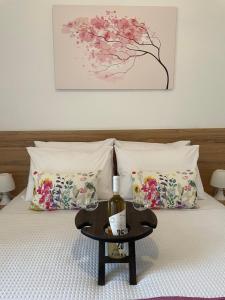 Una cama con una mesa con una botella de vino. en Sakura Dntwn, en Heraclión