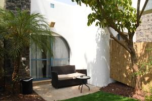 a patio with a black chair and a table at Nirvana Maayan Baruh in Ma‘yan Barukh