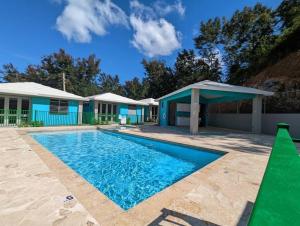 a swimming pool in front of a house at Villas at Chalet De Buye in Cabo Rojo