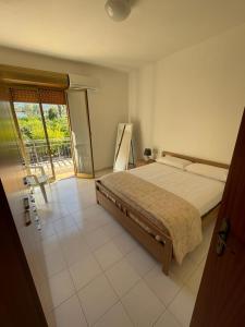 a bedroom with a large bed and a balcony at limoneto in Trabia