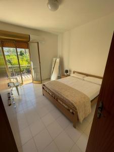 a bedroom with a large bed and a balcony at limoneto in Trabia