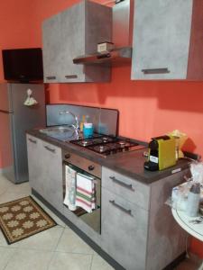 uma cozinha com um fogão e um lavatório em La lucerna delle dodici stelle em Piglio