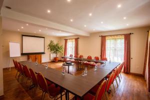 een grote vergaderzaal met een grote tafel en stoelen bij Hotel Turnul in Moieciu de Jos