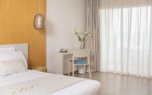 a bedroom with a bed and a desk and a window at Royal Azur Thalassa in Hammamet