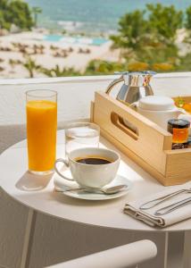 a table with a cup of coffee and a glass of orange juice at Royal Azur Thalassa in Hammamet