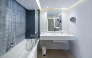 a bathroom with a sink and a shower and a tub at Royal Azur Thalassa in Hammamet