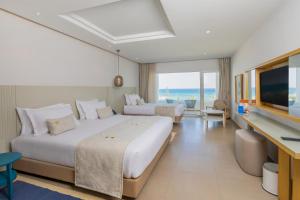 a hotel room with two beds and a flat screen tv at Royal Azur Thalassa in Hammamet