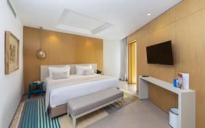 a bedroom with a large bed and a flat screen tv at Royal Azur Thalassa in Hammamet
