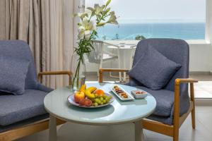 a table with a plate of fruit on it with two chairs at Royal Azur Thalassa in Hammamet