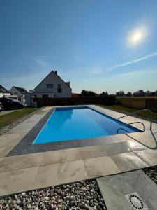 a swimming pool in a yard with a house at Aquarella in Trzęsacz