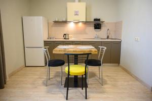 cocina con mesa, sillas y nevera en Space Apart Hotel, en Lutsk