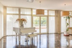 a white piano in a room with windows at Ona Benidorm Poniente in Benidorm