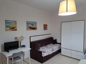 a bedroom with a bed and a desk and a television at Le Comete di Angelo in Reggio di Calabria
