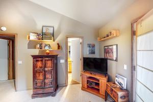 sala de estar con TV de pantalla plana en la pared en Sunny Side Lodge, en Ketchum