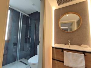 a bathroom with a shower and a sink and a mirror at Alojamiento San Basilio Suite in Córdoba