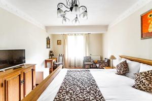 a bedroom with a large bed and a television at Hotel Turnul in Moieciu de Jos