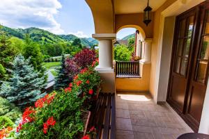 a balcony of a house with flowers and a view at Hotel Turnul in Moieciu de Jos