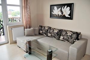 - un salon avec un canapé et une table basse en verre dans l'établissement Royal Apartments - Apartamenty Jagiełły, à Wrocław