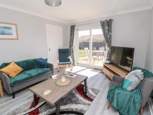 a living room with a couch and a table and a tv at 20 Southmead in Morpeth