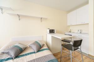 a bedroom with a bed and a desk and a kitchen at Smart House 11 in Kyiv