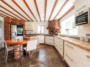 a kitchen with a wooden table and a dining room at Noah's Barn in Poulton le Fylde