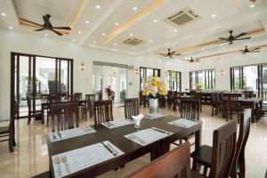 a dining room with tables and chairs and windows at DAD Resort Phú Quốc in Phú Quốc