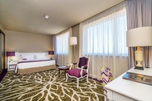 um quarto de hotel com uma cama e uma cadeira em Holiday Inn Porto Gaia, an IHG Hotel em Vila Nova de Gaia