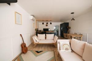 - un salon avec un canapé blanc et une guitare dans l'établissement Villa du domaine Mas Lafleur 4 personnes, à Châteaurenard