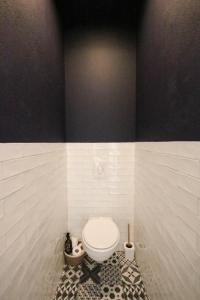 a bathroom with a toilet in a black and white wall at Villa du domaine Mas Lafleur 4 personnes in Châteaurenard