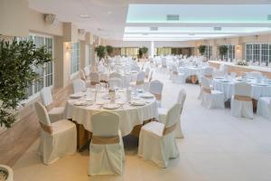 a large banquet hall with white tables and chairs at Sercotel Carlos III in Cartagena