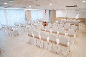 a conference room with white chairs and a table at Sercotel Carlos III in Cartagena