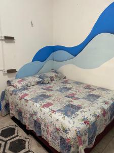 a bedroom with a bed and a wall with a mural at Hostel e Cachaçaria da Cris in Carolina