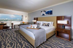 マイアミにあるインターコンチネンタル マイアミの大きなベッドとデスクが備わるホテルルームです。